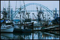 Commercial fishing boats and Yaquina Bay Bridge at dawn. Newport, Oregon, USA