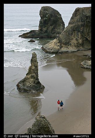 Women walking on beach among rock needles. Bandon, Oregon, USA