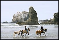 Women horse-riding on beach. Bandon, Oregon, USA