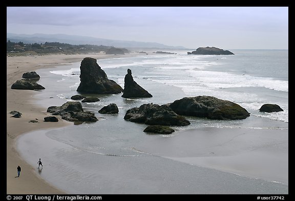 Beach at Face Rock with two people walking. Bandon, Oregon, USA