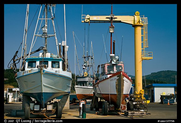 Fishing boats parked on deck with hoist behind, Port Orford. Oregon, USA (color)