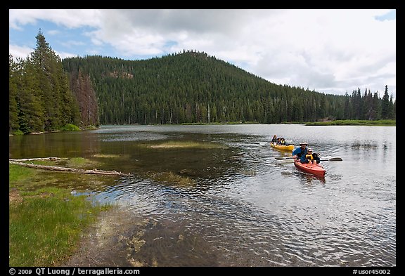 Parents towing children in kayak, Devils Lake. Oregon, USA
