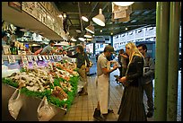 Countermen offer fish samples, Pike Place Market. Seattle, Washington (color)