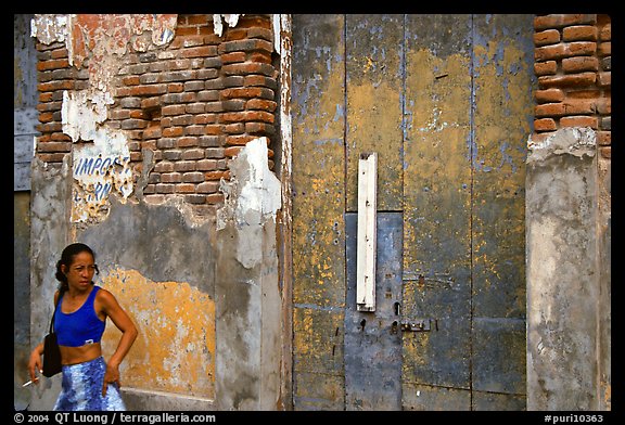 Woman in front of a decaying brick wall, Ponce. Puerto Rico