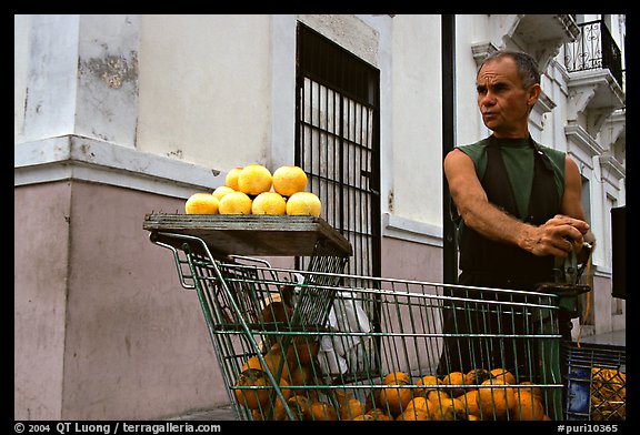 Man peeling oranges to make a drink, drunk from the fruit itself, Ponce. Puerto Rico (color)