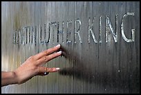 Hand touching the letters Martin Luther King in flowing water. Montgomery, Alabama, USA