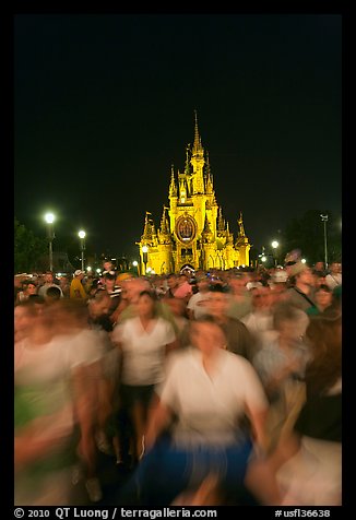 Crowds walking away from Cinderella Castle at night. Orlando, Florida, USA (color)