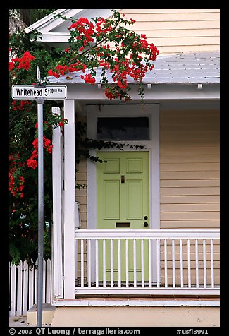 Pastel-colored house, tropical flowers, street sign. Key West, Florida, USA