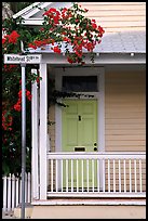 Pastel-colored house, tropical flowers, street sign. Key West, Florida, USA