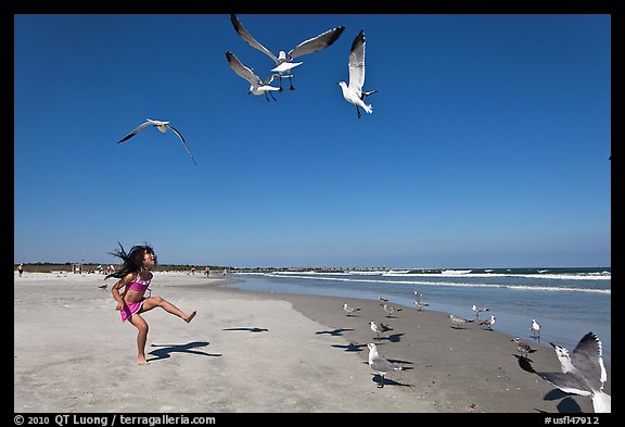 Beach with flying seagulls and girl, Jetty Park. Cape Canaveral, Florida, USA (color)