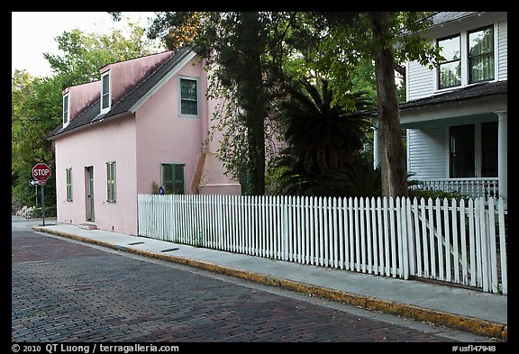 White picket fence and houses on cobblestone street. St Augustine, Florida, USA