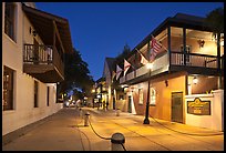 Old street and historic buildings with flags by night. St Augustine, Florida, USA