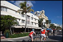 Cyclists passing Art Deco hotels, Miami Beach. Florida, USA