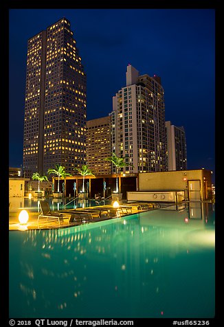 Pool surrouned by high rise towers at night, Miami. Florida, USA