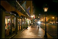 Restaurant, lamps, and sidewalk of River Street by night. Savannah, Georgia, USA