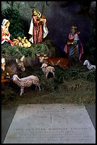 Tombstone of a French priest, and figures inside a replica of the Lourdes grotto, church Saint-Martin-de-Tours, Saint Martinville. Louisiana, USA (color)