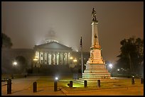 Monument to Confederate soldiers and state capitol at night. Columbia, South Carolina, USA
