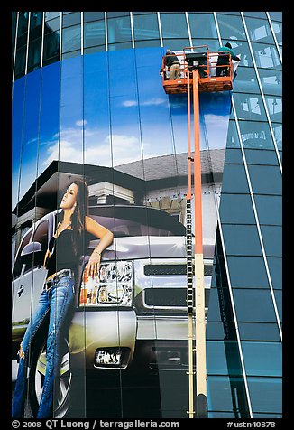 Workers pasting mural-sized car advertising on building. Nashville, Tennessee, USA (color)