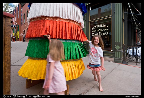 Girls spin tibetan prayer wheel. Telluride, Colorado, USA (color)