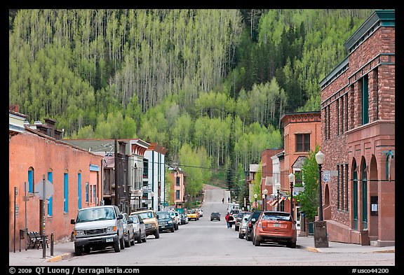 Historic brick buildings and slope with newly leafed aspens. Telluride, Colorado, USA