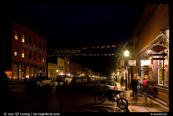 People walking by store on Colorado Street by night. Telluride, Colorado, USA