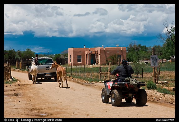 Rural road on the reservation with ATV, truck and horse. Taos, New Mexico, USA