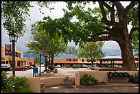 Plazza, trees and buildings in adobe style. Taos, New Mexico, USA