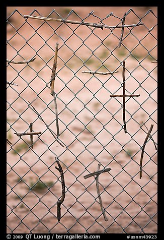 Crosses made of twigs on chain-link fence, Sanctuario de Chimayo. New Mexico, USA