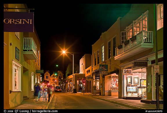 Street with galleries, people walking, and cathedral by night. Santa Fe, New Mexico, USA