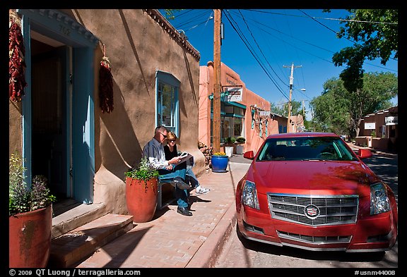Couple reading art magazine in front of gallery. Santa Fe, New Mexico, USA
