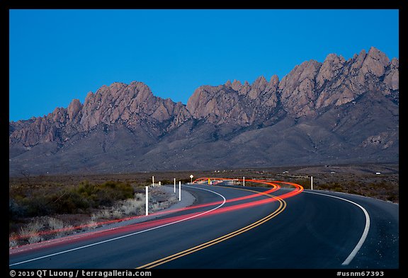 Road with light trails and Organ Mountains at dusk. Organ Mountains Desert Peaks National Monument, New Mexico, USA