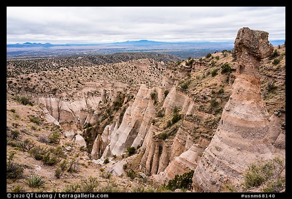 Tent rock with caprock overlooking mesa with distant Sangre de Cristo and Jemez Mountains. Kasha-Katuwe Tent Rocks National Monument, New Mexico, USA (color)