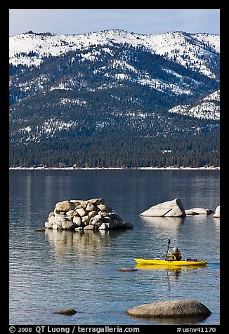 Kayaker with backdrop of snow-covered mountains, Lake Tahoe-Nevada State Park, Nevada. USA