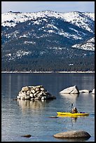 Kayaker with backdrop of snow-covered mountains, Lake Tahoe-Nevada State Park, Nevada. USA