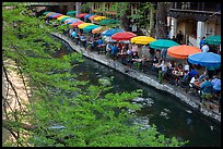 Tables under colorful umbrellas next to canal. San Antonio, Texas, USA ( color)