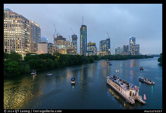 Skyline and tour boats on Colorado River at dusk. Austin, Texas, USA