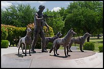 Bronze sculptures of four dogs and handler seated on granite pedestal, Military Working Dog Teams National Monument. San Antonio, Texas, USA ( color)