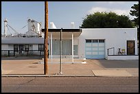 Minimalist white facade, grain elevators beyond, Marfa. Texas, USA ( color)