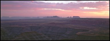 Sunset over canyon and distant mesas. Monument Valley Tribal Park, Navajo Nation, Arizona and Utah, USA (Panoramic color)