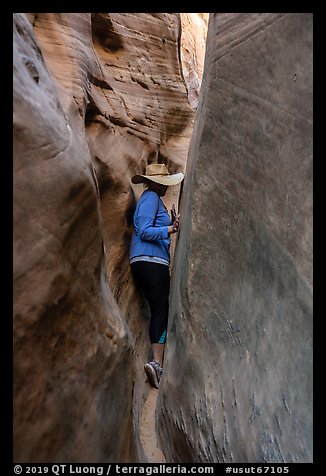 Woman squeezing in Zebra Slot Canyon. Grand Staircase Escalante National Monument, Utah, USA