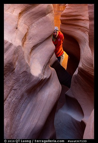 Man inside Peek-a-Boo slot canyon. Grand Staircase Escalante National Monument, Utah, USA