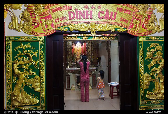 Woman with girl worshipping at Dinh Cau temple, Duong Dong. Phu Quoc Island, Vietnam