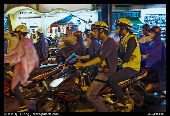 Street crowded with motorcycles on rainy night. Ho Chi Minh City, Vietnam