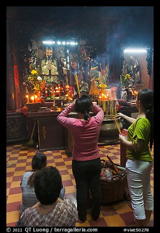 Women offering incense to Jade Emperor figure, Phuoc Hai Tu pagoda, district 3. Ho Chi Minh City, Vietnam