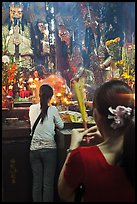 Women holding incense sticks, Phuoc Hai Tu pagoda, district 3. Ho Chi Minh City, Vietnam ( color)