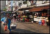 Woman carrying goods on street market. Ho Chi Minh City, Vietnam ( color)