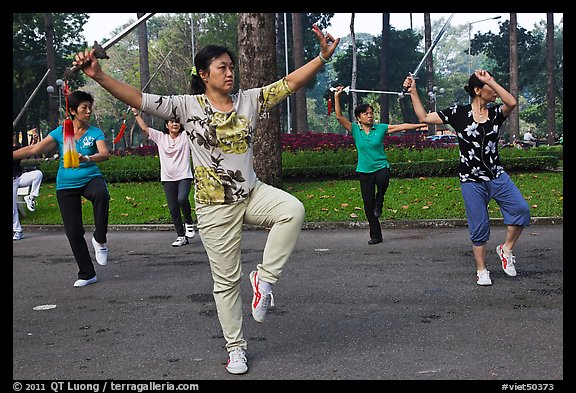 People practicisng Tai Chi with swords, Tao Dan Park. Ho Chi Minh City, Vietnam (color)