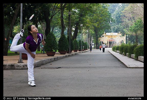 Woman plays badminton using feet (footbag), Tao Dan Park. Ho Chi Minh City, Vietnam