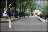 Woman plays badminton using feet (footbag), Tao Dan Park. Ho Chi Minh City, Vietnam ( color)