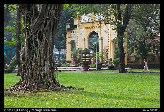 Tree, lawn, and gate, Van Hoa Park. Ho Chi Minh City, Vietnam